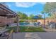 Relaxing backyard with a pristine pool, covered patio, and lush artificial turf, creating a serene escape at 2504 Courlan Dr, North Las Vegas, NV 89084