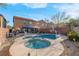 Spacious backyard featuring a sparkling pool and spa, lush landscaping, and comfortable seating areas at 2504 Courlan Dr, North Las Vegas, NV 89084