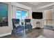 This comfortable seating area features two blue chairs, hardwood floors, a wall-mounted TV, and sliding glass doors at 2700 Las Vegas Blvd # 1803, Las Vegas, NV 89109