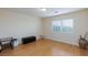 Neutral bedroom with hardwood floors, ample light and a black leather ottoman at 3043 Jacaranda Dr, Las Vegas, NV 89117