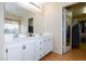 Bathroom featuring dual vanities, a large mirror, and an adjacent walk-in closet at 3043 Jacaranda Dr, Las Vegas, NV 89117