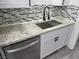 Modern kitchen with stainless steel appliances, white cabinets, granite countertops, and mosaic backsplash at 310 E Lake Mead Blvd, North Las Vegas, NV 89030
