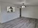 Living room with gray wood-look floors, white walls, and ceiling fan at 310 E Lake Mead Blvd, North Las Vegas, NV 89030