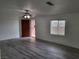 Living room with gray wood-look floors, white walls, ceiling fan and view of front door at 310 E Lake Mead Blvd, North Las Vegas, NV 89030
