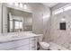 Bathroom vanity area with marble countertops, a shower, and tile walls at 3120 S Torrey Pines Ave, Pahrump, NV 89048