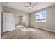 Bright bedroom features a ceiling fan, wood floors, large window, and closet with mirrored doors at 3120 S Torrey Pines Ave, Pahrump, NV 89048