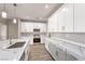 Contemporary kitchen boasting white cabinets, stainless steel appliances, marble counters, and modern pendant lighting at 3120 S Torrey Pines Ave, Pahrump, NV 89048