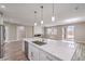 Modern kitchen with an island, stainless steel appliances, stone fireplace, and sliding glass doors to the outside at 3120 S Torrey Pines Ave, Pahrump, NV 89048