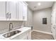 Functional laundry room includes a sink, plenty of cabinet space, and neutral wall color at 3120 S Torrey Pines Ave, Pahrump, NV 89048