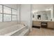 Bright bathroom features a soaking tub with a stained glass window and double sink vanity at 344 Mill Hollow Rd, Las Vegas, NV 89107