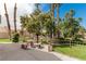 Outdoor common area with shaded table, seating, manicured landscaping, and mature trees at 344 Mill Hollow Rd, Las Vegas, NV 89107