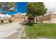 Nice single-story home with a two-car garage, surrounded by mature trees and a green lawn at 344 Mill Hollow Rd, Las Vegas, NV 89107