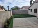 Private backyard with a concrete patio, artificial grass, and block wall fencing at 3616 Rose Canyon Dr, North Las Vegas, NV 89032