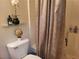 Compact bathroom featuring a toilet with decorative accents and a shower with a patterned curtain at 3616 Rose Canyon Dr, North Las Vegas, NV 89032