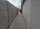 Narrow side yard with a concrete walkway and block wall fencing at 3616 Rose Canyon Dr, North Las Vegas, NV 89032
