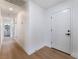 Bright hallway with wood-look floors leading to a bathroom, and a white front door at 3915 Delling Ct, Las Vegas, NV 89104