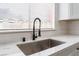 Close up of a stainless steel kitchen sink with a modern faucet, quartz countertops, and white cabinetry at 3915 Delling Ct, Las Vegas, NV 89104