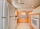 Bright kitchen with white appliances, light wood cabinets, white tile floor and granite countertops at 43 E Agate Ave # 305, Las Vegas, NV 89123