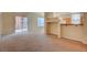 Bright living room featuring beige carpet, a partial wall, a sliding door, and multiple windows at 43 E Agate Ave # 305, Las Vegas, NV 89123