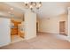 Bright living room featuring neutral carpet, pendant lighting, and pass-through to the kitchen at 43 E Agate Ave # 305, Las Vegas, NV 89123