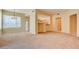 Spacious living room with neutral carpet, large window, pendant lighting, and pass-through to the kitchen at 43 E Agate Ave # 305, Las Vegas, NV 89123