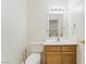 Bright bathroom features a single sink vanity, toilet, and a mirror reflecting the laundry area at 4712 Belshire Dr, Las Vegas, NV 89147