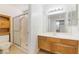 Bathroom featuring wood cabinets, a white sink, a shower with glass doors, and tile flooring at 4712 Belshire Dr, Las Vegas, NV 89147