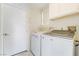 Functional laundry room equipped with a Whirlpool washer and dryer, overhead cabinets, and a convenient access door at 4712 Belshire Dr, Las Vegas, NV 89147