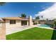 Inviting backyard boasts a pool, artificial grass area, and sliding glass doors offering seamless indoor-outdoor living at 4855 San Sebastian Ave, Las Vegas, NV 89121