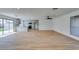 Spacious living room with sleek wood-style floors, neutral walls, and modern lighting leading to a contemporary kitchen at 4855 San Sebastian Ave, Las Vegas, NV 89121