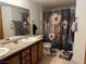 Bathroom with double sinks, granite countertop, and a shower with a decorative floral shower curtain at 5055 W Hacienda Ave # 2175, Las Vegas, NV 89118