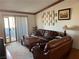 Relaxing living room featuring leather furniture, a sliding glass door to the balcony, and decorative wall art at 5055 W Hacienda Ave # 2175, Las Vegas, NV 89118