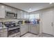 Bright kitchen featuring gray cabinets, granite countertops, and stainless steel appliances at 5093 Sun Valley Dr, Las Vegas, NV 89122