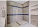 Modern bathroom featuring a glass shower with blue tile accents and adjacent walk in closet at 6 Lilla Rosa St, Henderson, NV 89011