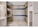Modern bathroom featuring a glass shower with blue tile accents, double sink vanity, and a walk in closet at 6 Lilla Rosa St, Henderson, NV 89011