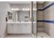 Modern bathroom featuring a glass shower with blue tile accents and double sink vanity with ample storage space at 6 Lilla Rosa St, Henderson, NV 89011