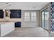 Contemporary kitchen view showcases stylish blue cabinets, white countertops and backsplash, and luxury tile floors at 6 Lilla Rosa St, Henderson, NV 89011