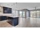 Open-concept living space with modern kitchen, tile floors and natural light from sliding glass doors at 6 Lilla Rosa St, Henderson, NV 89011