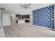 Bright living room with open layout, accented wallpaper, ceiling fan, and modern kitchen view at 6 Lilla Rosa St, Henderson, NV 89011