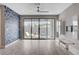 Open-concept living room featuring tile floors, a stylish accent wall, and sliding door access to the outdoor pool at 6 Lilla Rosa St, Henderson, NV 89011