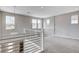 Elevated view of a modern, open loft space with railing, plush carpet, and bright light fixtures at 6 Lilla Rosa St, Henderson, NV 89011