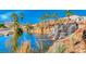 Picturesque view featuring a waterfall, pond, mature trees, and desert landscaping at 6 Lilla Rosa St, Henderson, NV 89011