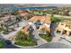 Aerial view of a white stucco home with a red tile roof and paver driveway, golf course and lake at 6 Rue Du Ville Way, Henderson, NV 89011