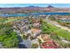 Community aerial view with lake and mountains in the background, featuring tile-roofed luxury homes at 6 Rue Du Ville Way, Henderson, NV 89011
