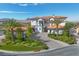 A white stucco home with a red tile roof, paver driveway, and lush landscaping at 6 Rue Du Ville Way, Henderson, NV 89011
