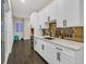 Modern kitchenette with white cabinets, granite countertops, and stylish backsplash at 6 Rue Du Ville Way, Henderson, NV 89011