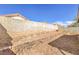 Backyard featuring gravel landscaping, brick retaining wall, and a block fence for privacy at 620 Macbrey Dr, Las Vegas, NV 89123