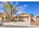 Inviting single-story home featuring a red-tiled roof and mature tree in the front yard at 620 Macbrey Dr, Las Vegas, NV 89123