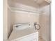 A compact laundry room with white walls, shelving, and a front-load washing machine at 620 Macbrey Dr, Las Vegas, NV 89123