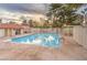 Community pool area with clear blue water, lounge chairs, and a covered seating area at 620 Macbrey Dr, Las Vegas, NV 89123
